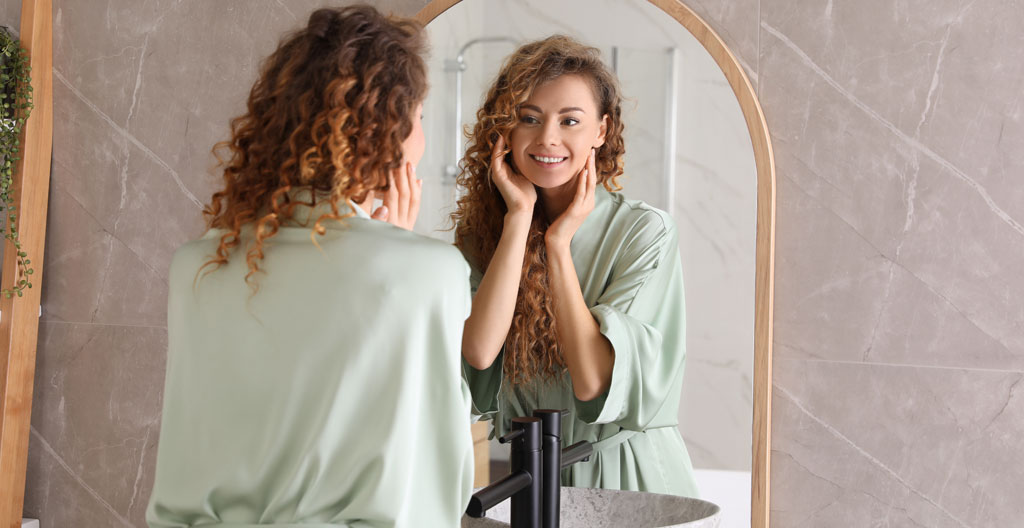 Femme exprimant une légère déception devant un miroir après une coupe de cheveux