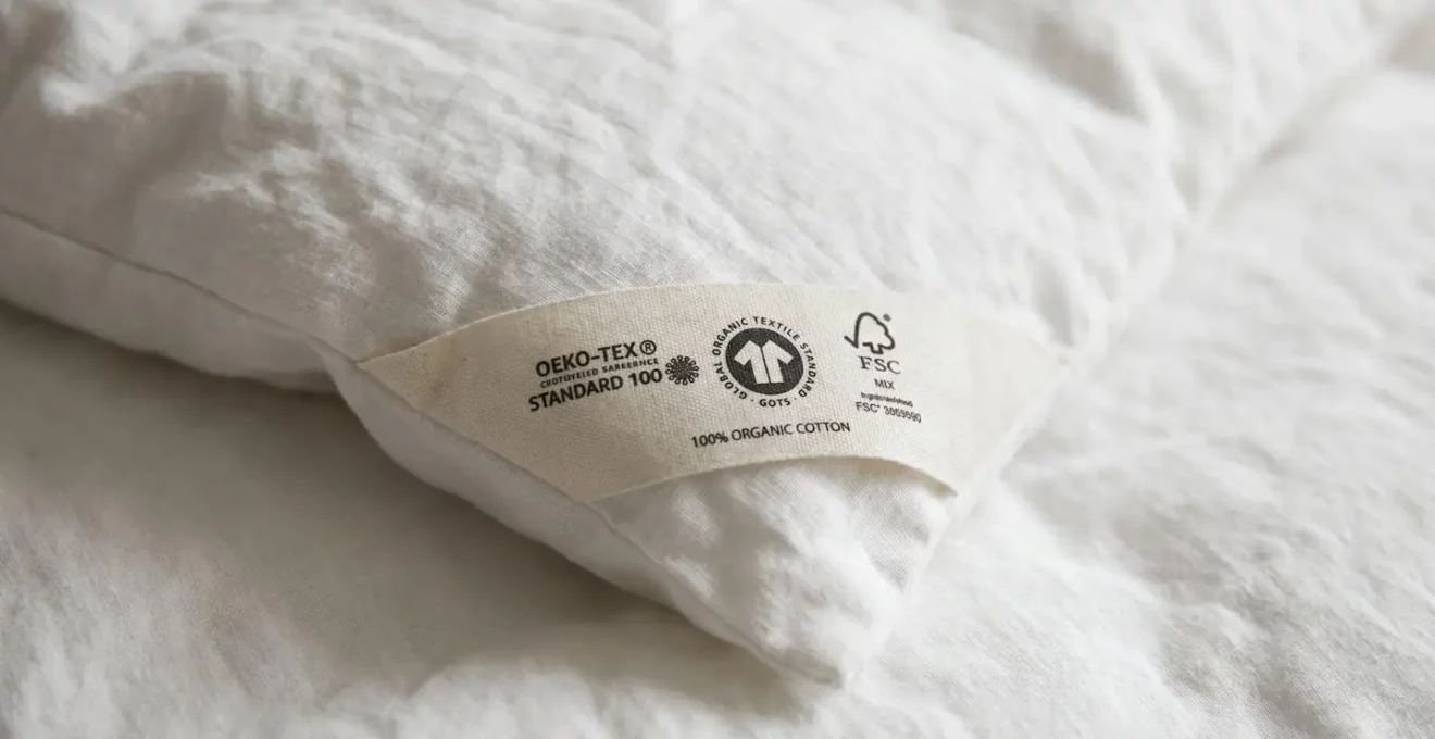 Étiquette de couette montrant un label Oeko-Tex et la mention fabrication française, posée sur un lit